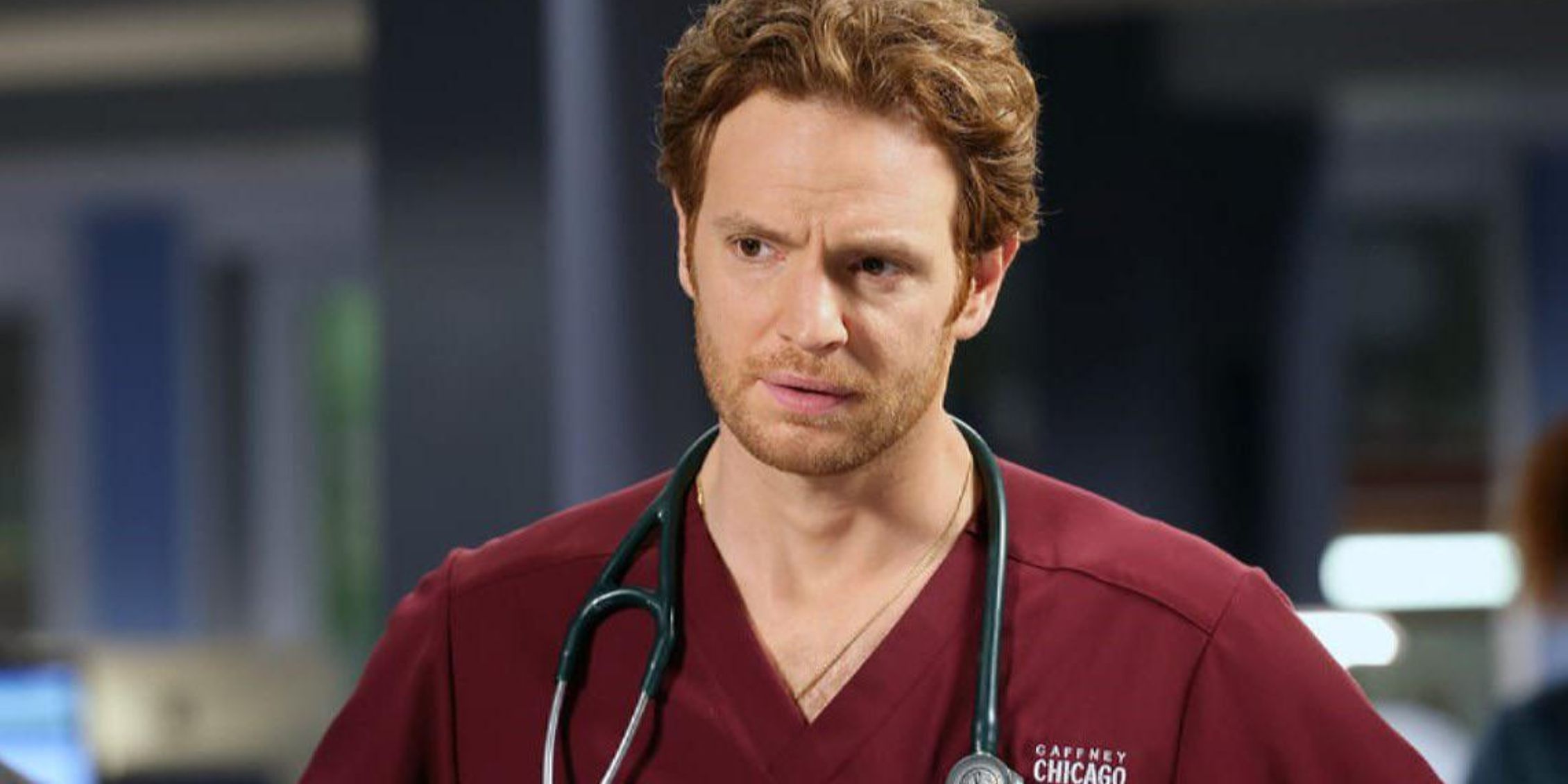 Chicago Med  Will Halstead wearing red scrubs and stethoscope around his neck