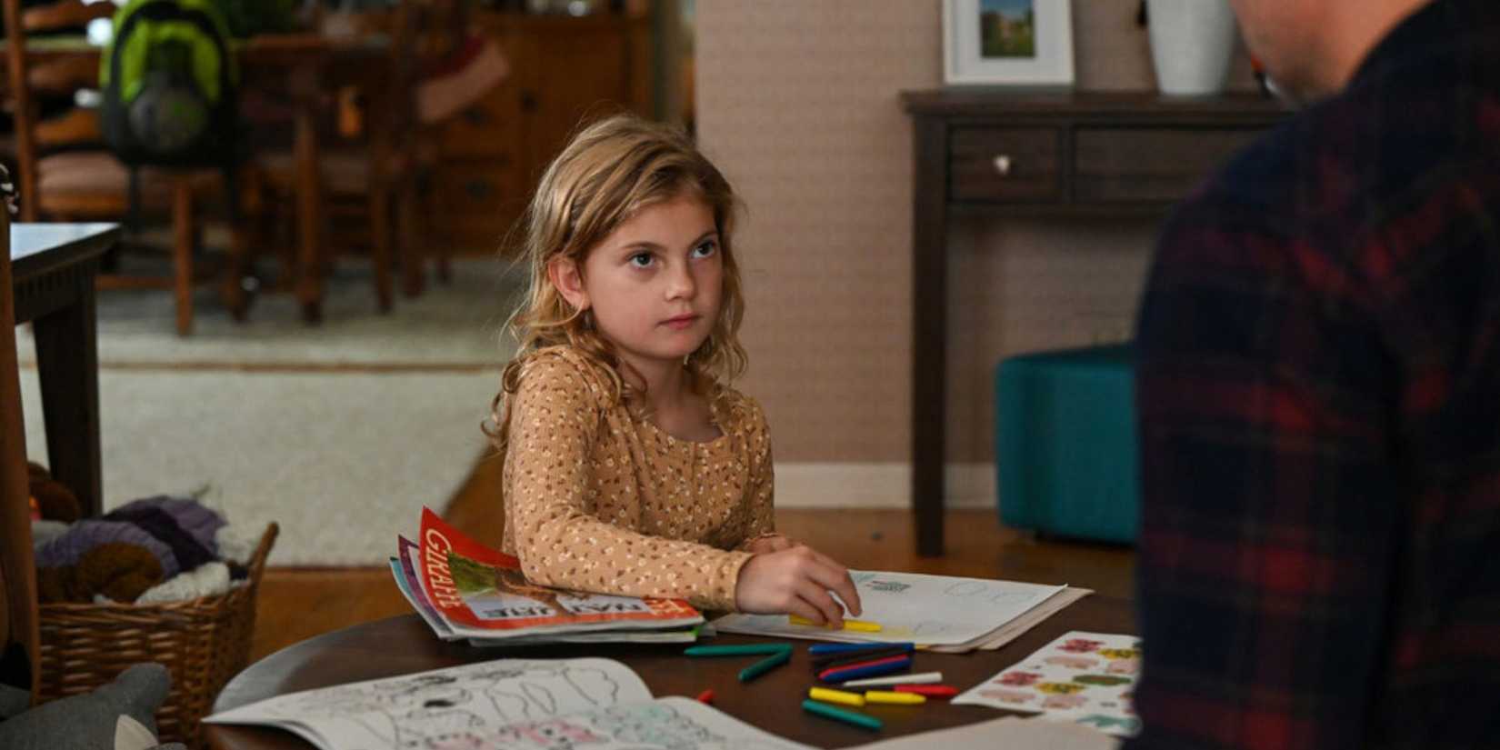 Chicago PD Zoe sitting at a table drawing and looking up at Adam