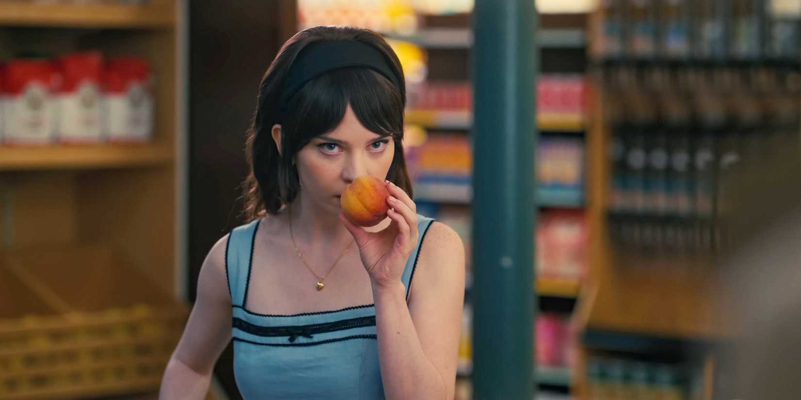 Sophie Thatcher as Iris smelling a fruit