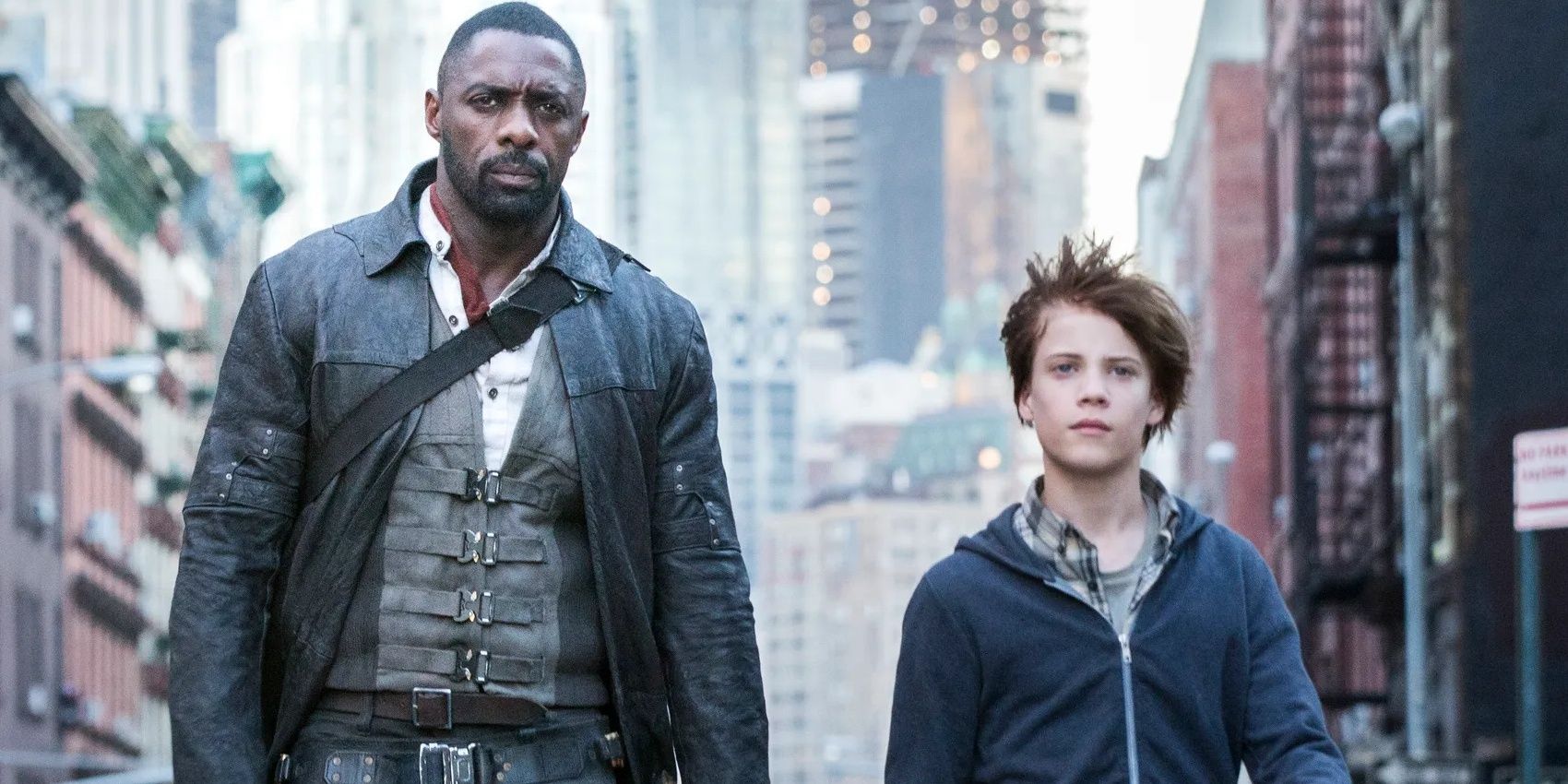 Roland Deschain (Idris Elba) e Jake Chambers (Tom Taylor) caminhando pelas ruas da Torre Negra (2017)