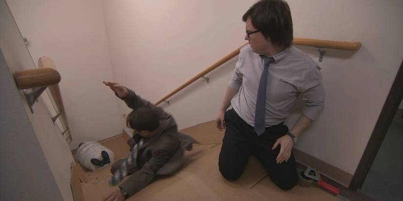 Dwight and Clark slide Stanley down the stairs in The Office