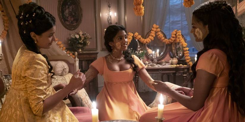 Edwina (Charithra Chandran), Kate (Simone Ashley), and Mary (Shelley Conn) sitting in a circle celebrating Haldi.