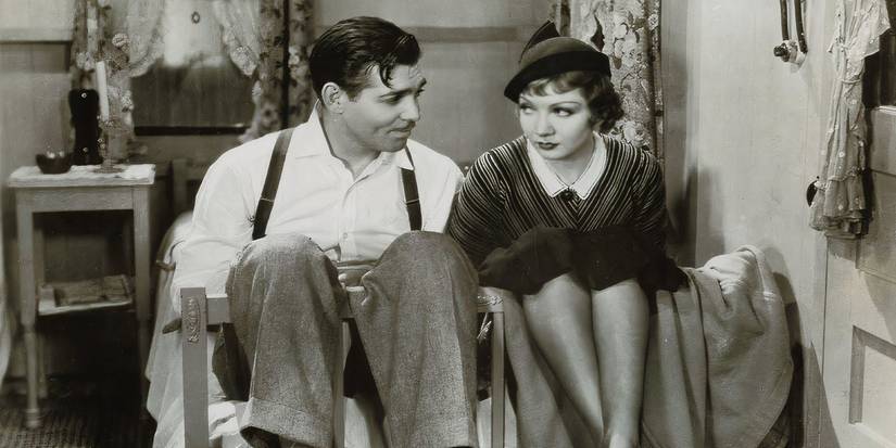 Ellie and Peter sit on a bed in It Happened One Night