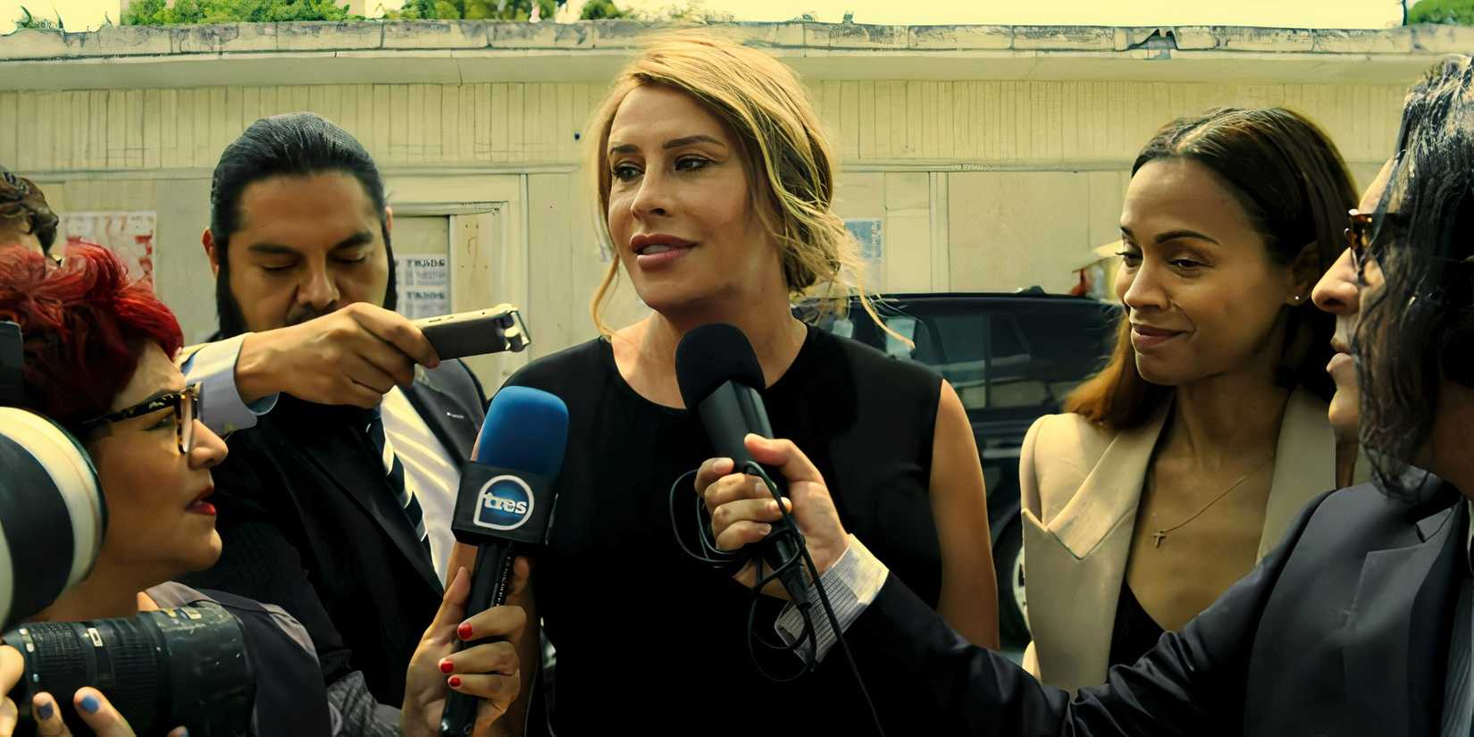 Emilia speaks to a group of reporters with Zoe Saldana beside her in Emilia Perez