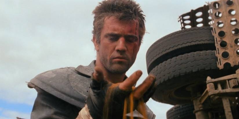 Max Rockatansky (Mel Gibson) looks confused as sand pours from his hand in Mad Max 2: The Road Warrior