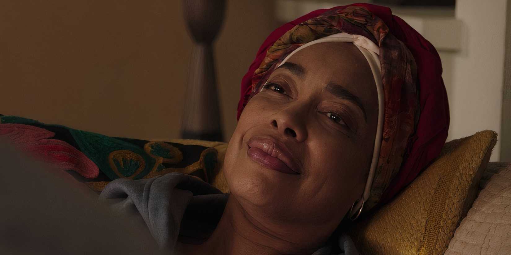 Gina Torres as Tommy smiling while laying down in 9-1-1 Lone Star season 5 episode 11