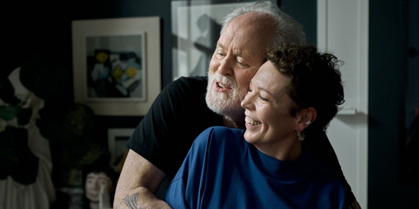 John Lithgow hugs Olivia Colman from behind in Jimpa