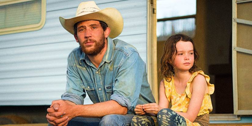 Josh O'Connor sits with his character's daughter on the front porch of their mobile home in Rebuilding