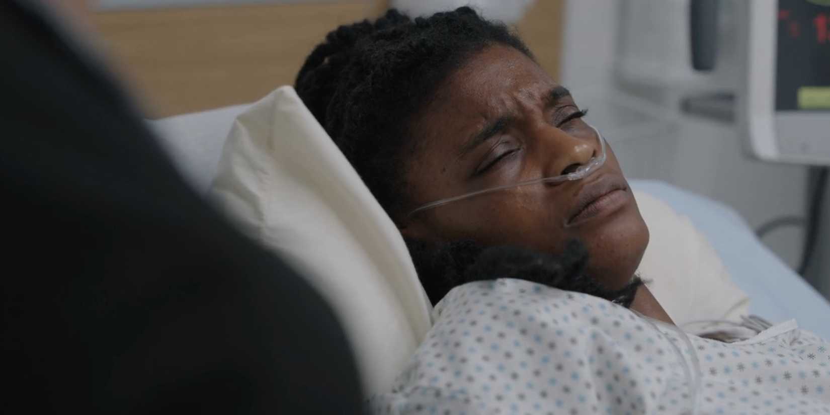 Joyce St. Claire (Ashley Romans) looking uncomfortable in a hospital bed in The Pitt season 1, episode 2