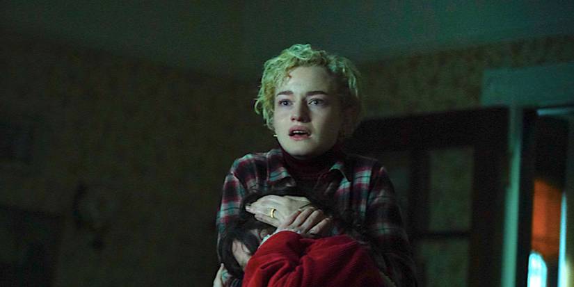 Julia Garner's Charlotte cradles her child while looking terrified in Wolf Man 2025