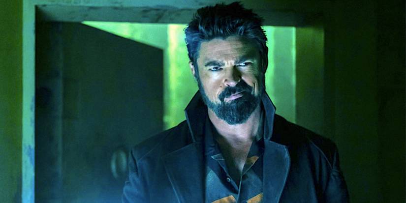 Karl Urban's Billy Butcher smirks in a dark room in The Boys
