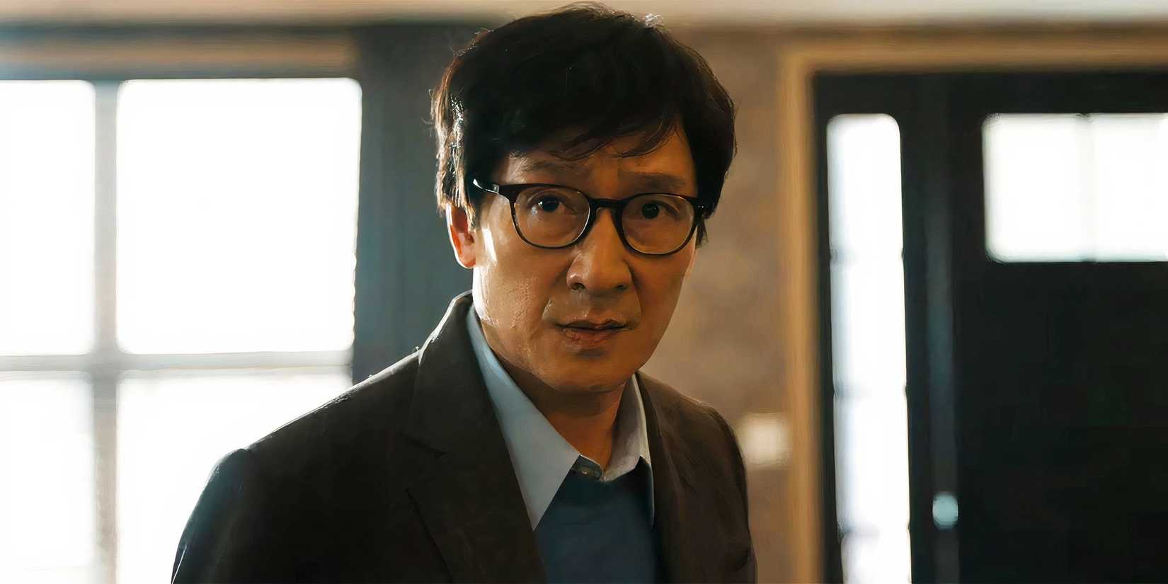 Ke Huy Quan as Marvin looking concerned standing in his living room in Love Hurts