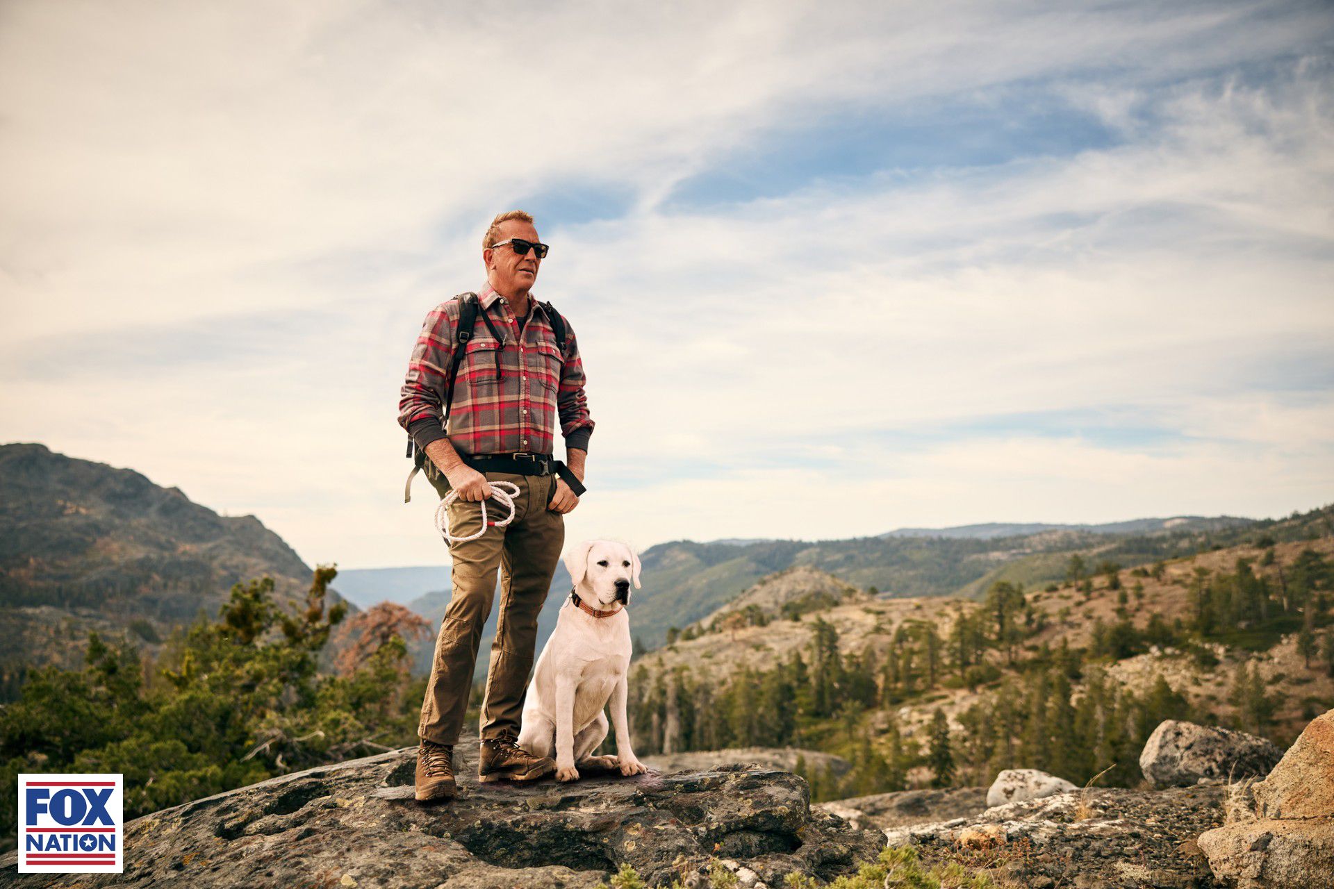 Kevin Costner posa con un perro en una roca en Yellowstone en Josemiti con Kevin Costner