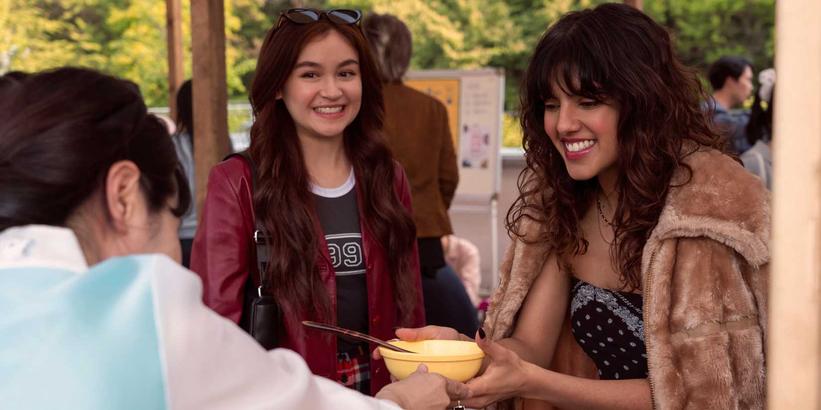 Kitty smiles at Praveena as she hold a bowl of food in XO, Kitty season 2, episode 3
