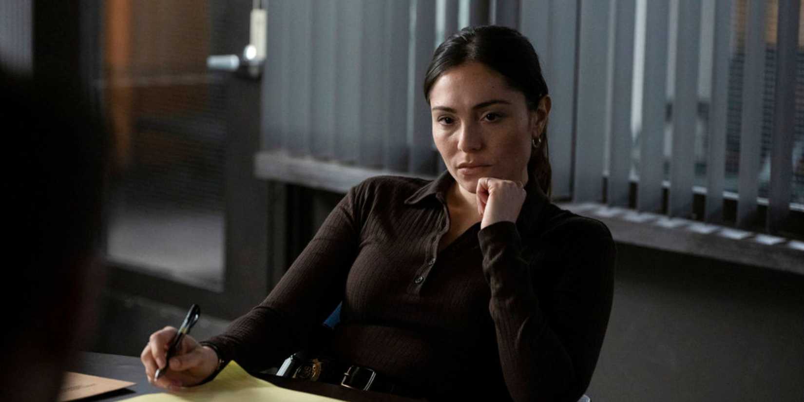 Law & Order SVU Silva (Juliana Aidén Martinez) sitting at her desk looking pensive and writing on a yellow legal pad