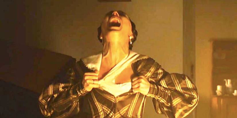 Lily-Rose Depp as Ellen tears at her corset in Nosferatu 2024