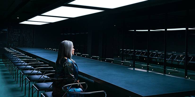 Ms Cobel sits in a conference room alone at Lumon at night in Severance season 2