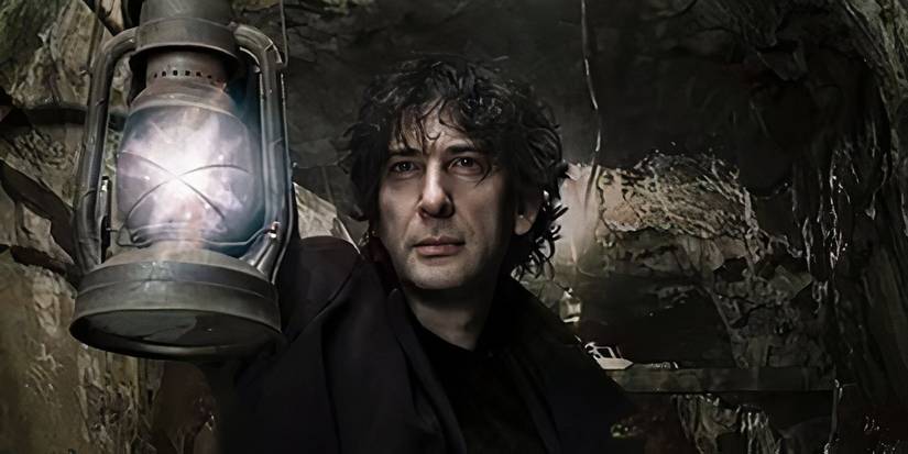 Neil Gaiman holding a lantern in a cave