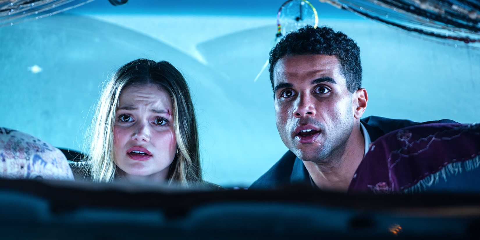 Olivia Holt And Mason Gooding In The Front Seat Of A Van Looking Toward The Back In Heart Eyes