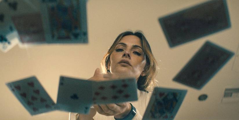 Gabriela (Sarah Shahi) looking at cards on a coffee table in Paradise