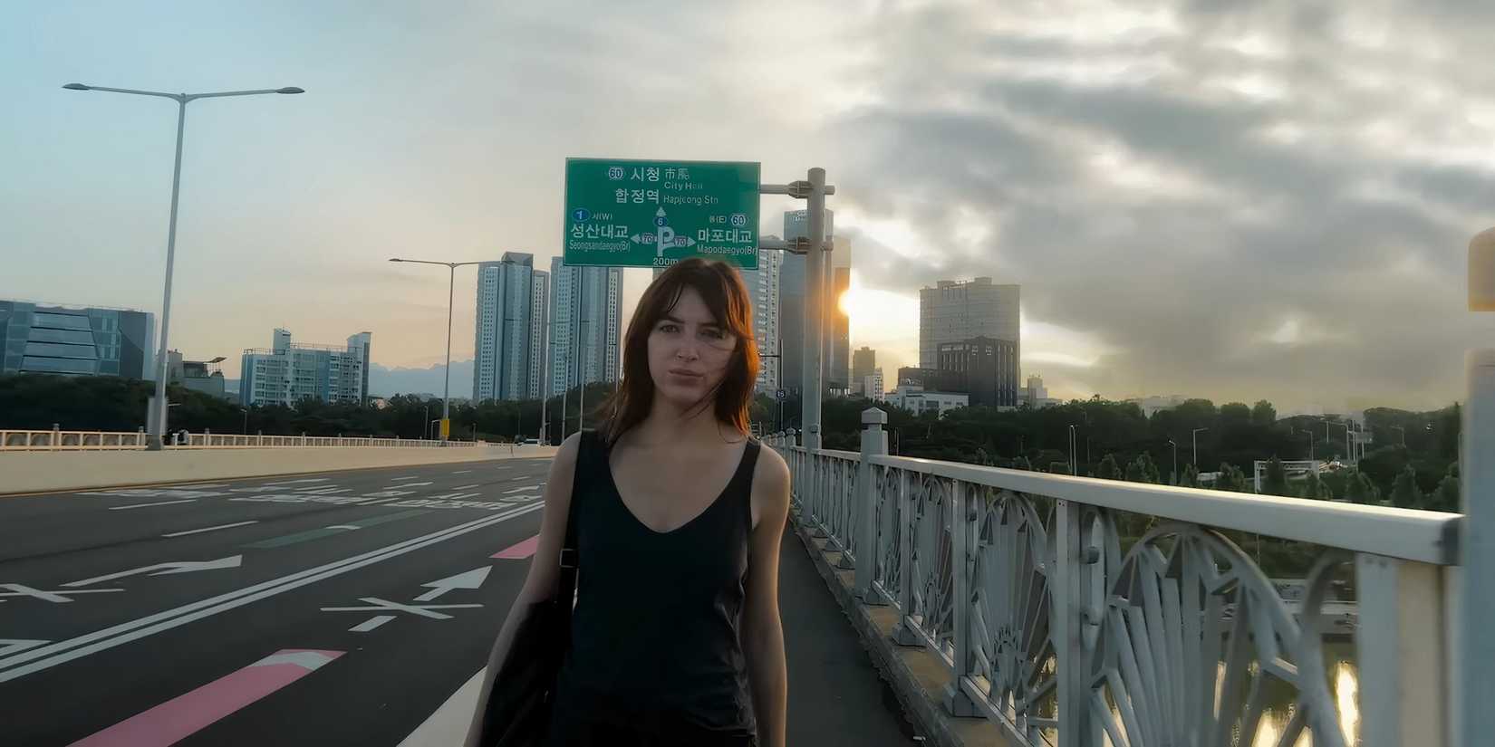 Phoebe Dynevor as Maya walking down a street in Inheritance