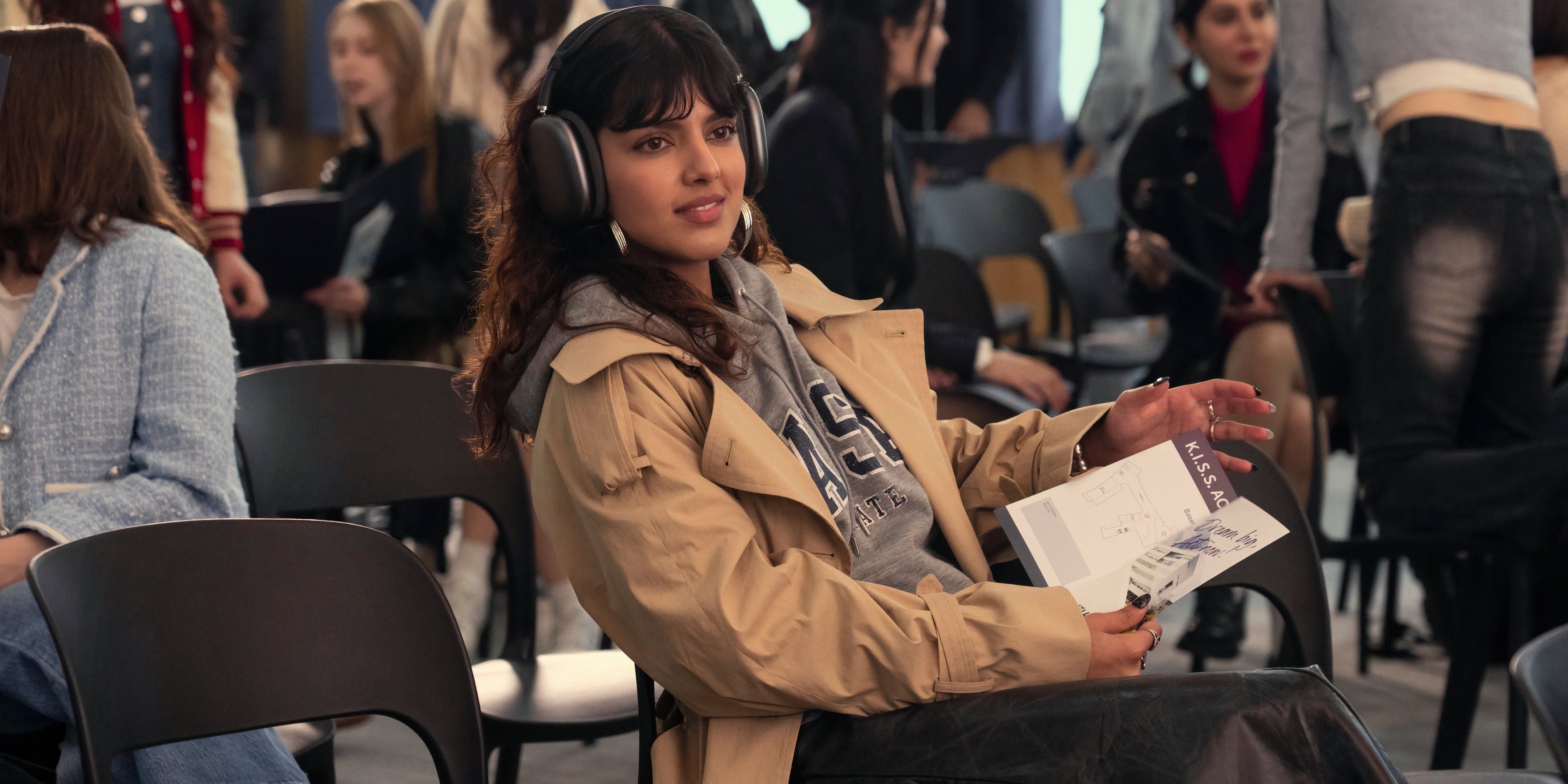 Praveena sits in a chair with headphones on in XO, Kitty season 2, episode 1