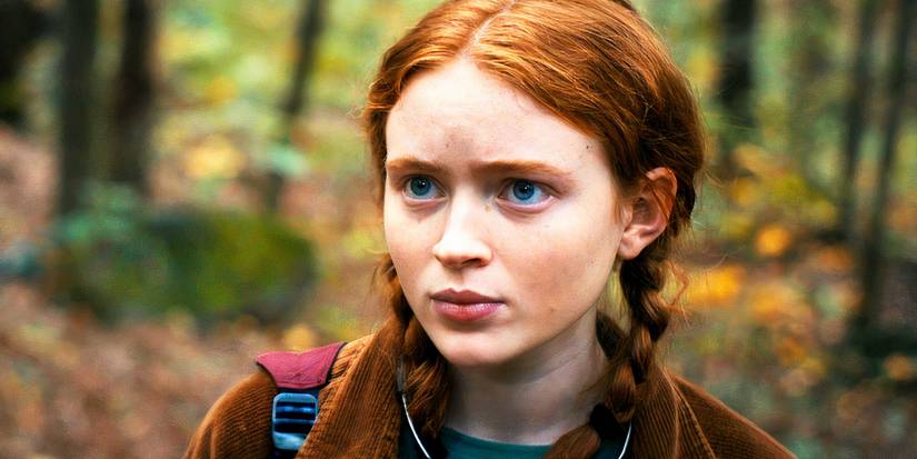 Sadie Sink as Max Mayfield standing in the woods in Stranger Things season 4