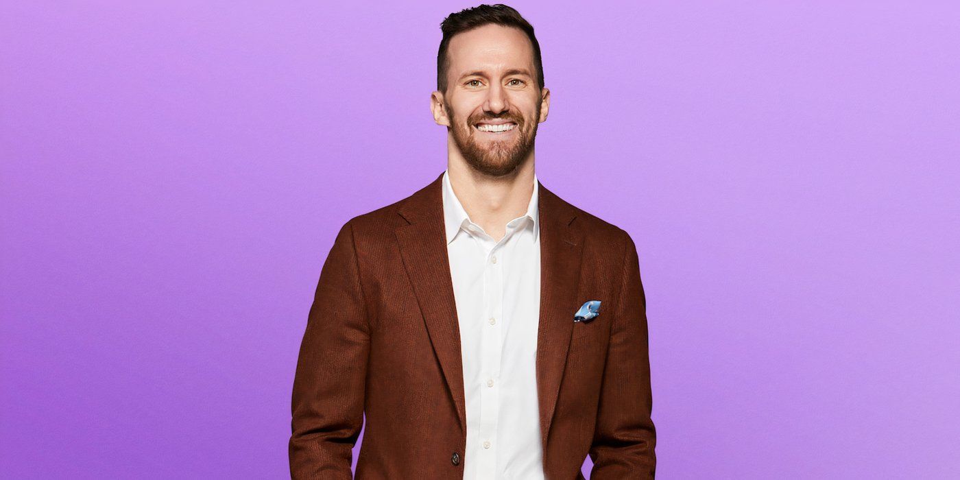 Love is Scott Sanderson season 8, wearing a brown jacket and white shirt while smiling during the promotional photo shoot.