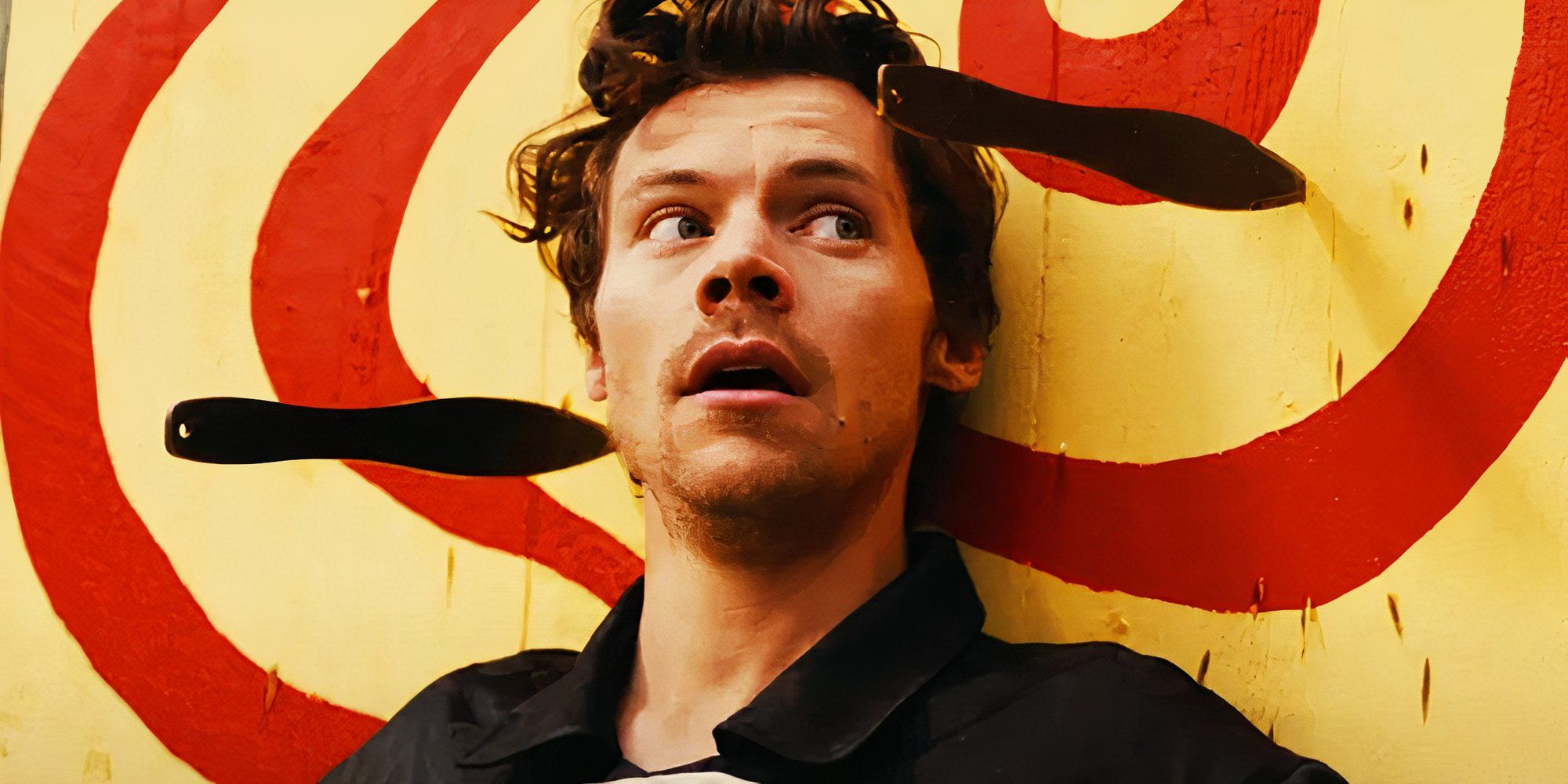 Harry Styles seems to panic with a blade that was thrown near his head, with another on the other side, in his music video "Daylight."