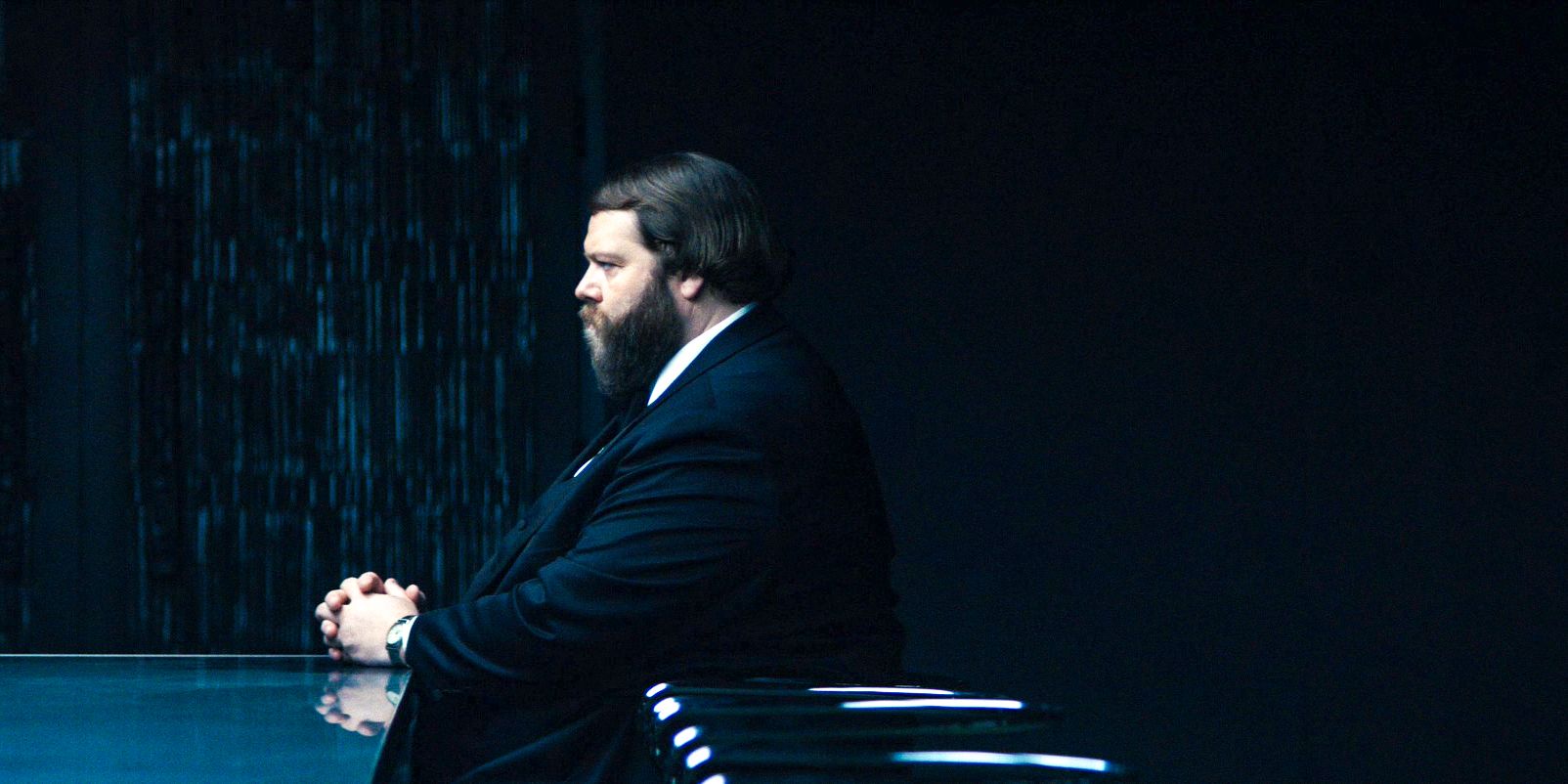 Drummond (Ólafur Darri Ólafsson) looking serious and sitting at a conference table in Season 2 of Severance