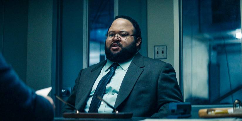 Zach Cherry sitting in an office in Severance season 2