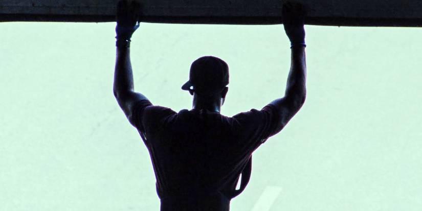 Stephan James stands surrounded by people with their hands on him, praying for him in Ricky (1)