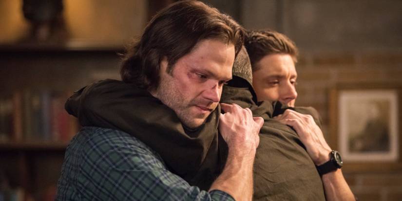 Sam and Dean hug John Winchester in Supernatural.