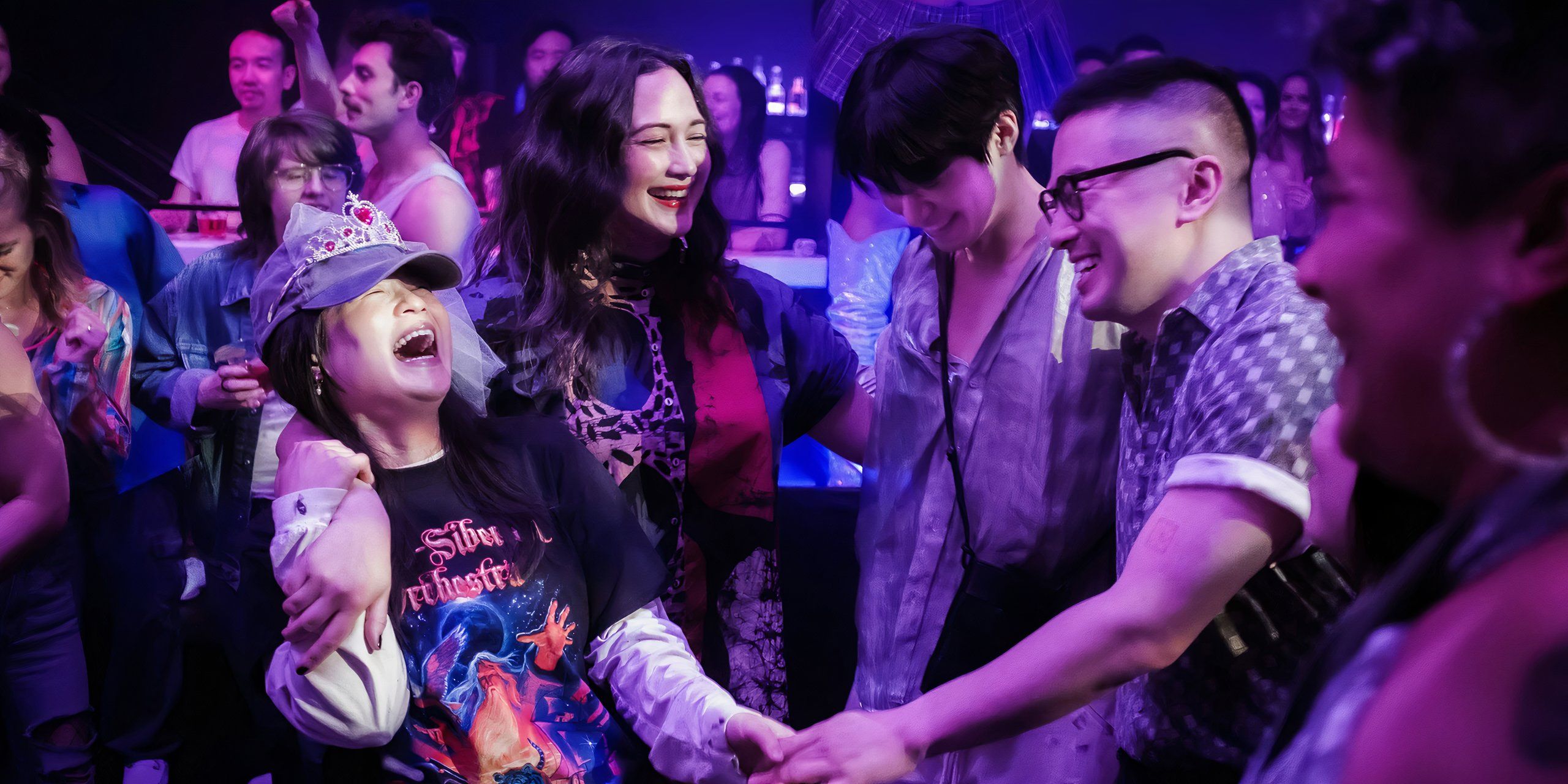 The cast of The Wedding Banquet laughing while dancing