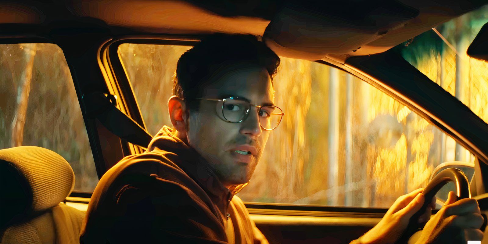 Theo James looking worried behind the wheel of a car in The MOnkey