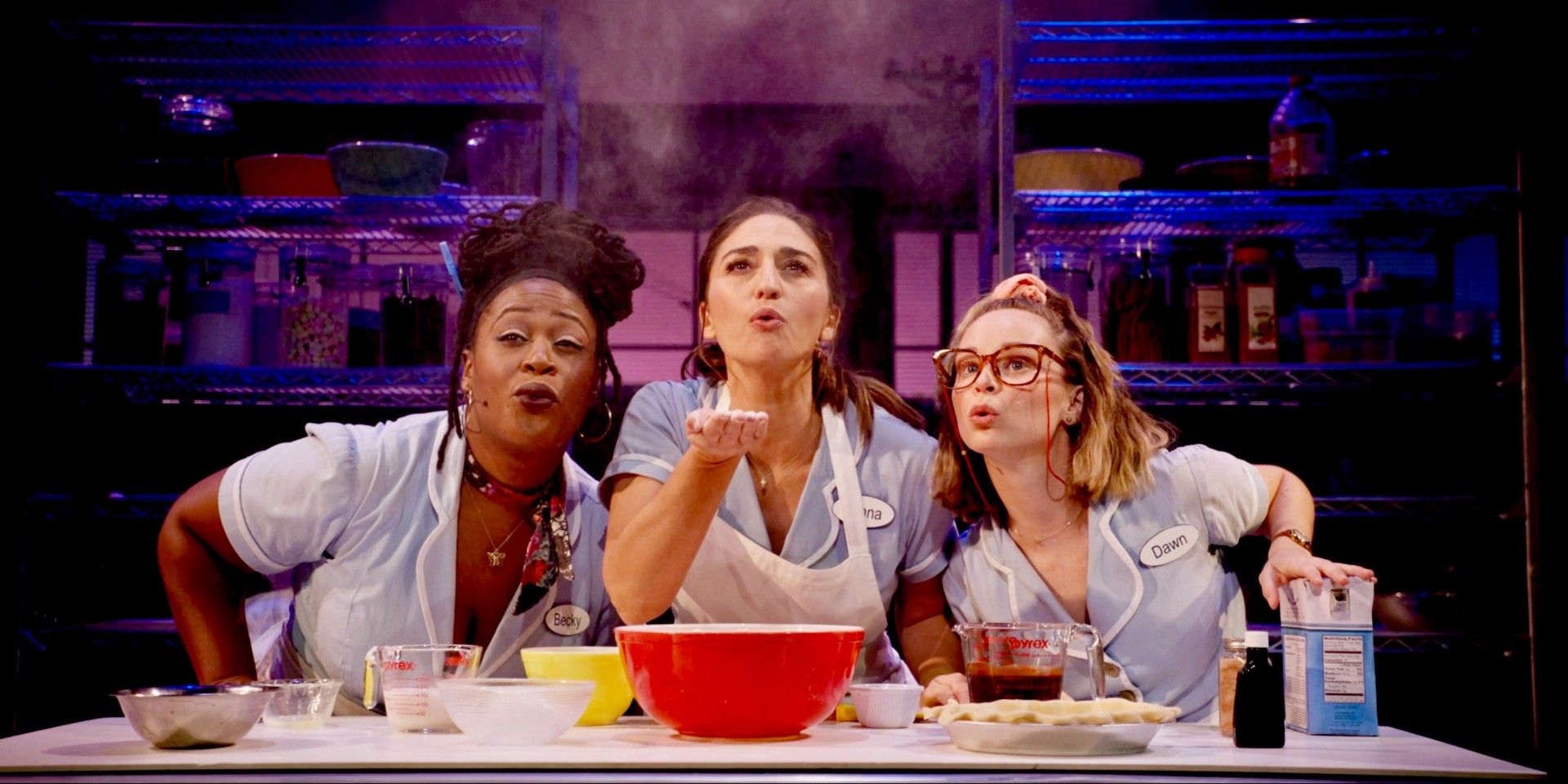 three women blowing sugar into the air in Waitress The Musical