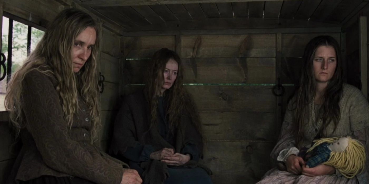 three women from the homesman looking sad in a the back of a wagon