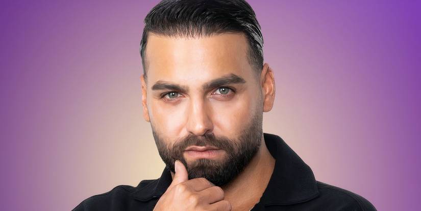 Love Is Blind: Germany season 1 Tolga looking serious in a promo shot with his thumb touching his chin