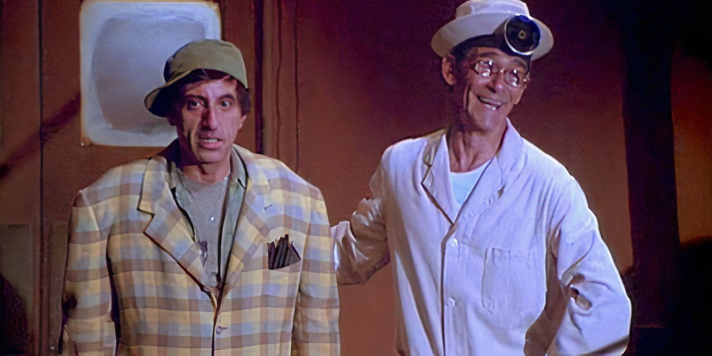 Klinger looking awkward while standing next to a smiling Fast Freddie Nichols in MASH's "That's Show Biz."