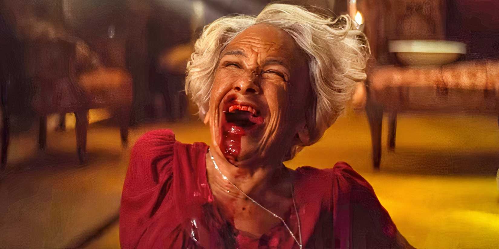 Kathryn Hunter as Solange laughing hysterically with blood smeared across her mouth in The Front Room