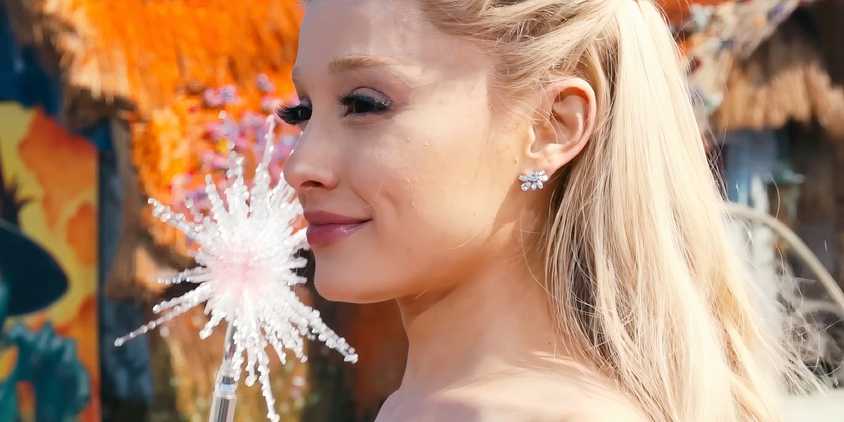 Ariana Grande as Glinda viewed in profile while holding her wand in Wicked