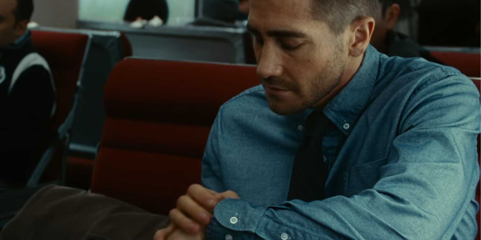 Jake Gyllenhaal checking his watch as Colter Stevens in Source Code