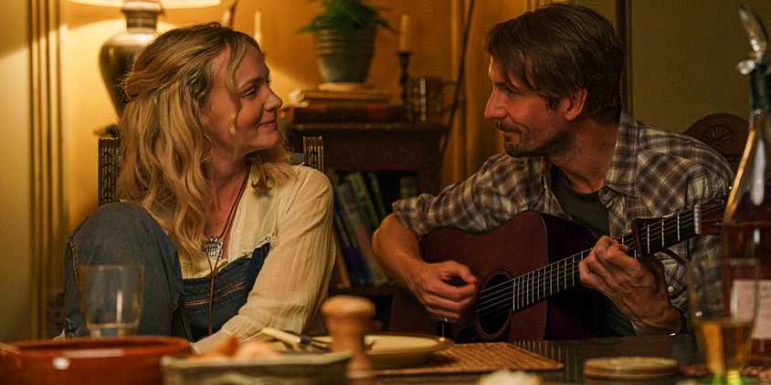 UntitledNell and Herb look at each other smiling while Herb plays guitar in Ballad of Wallis Island