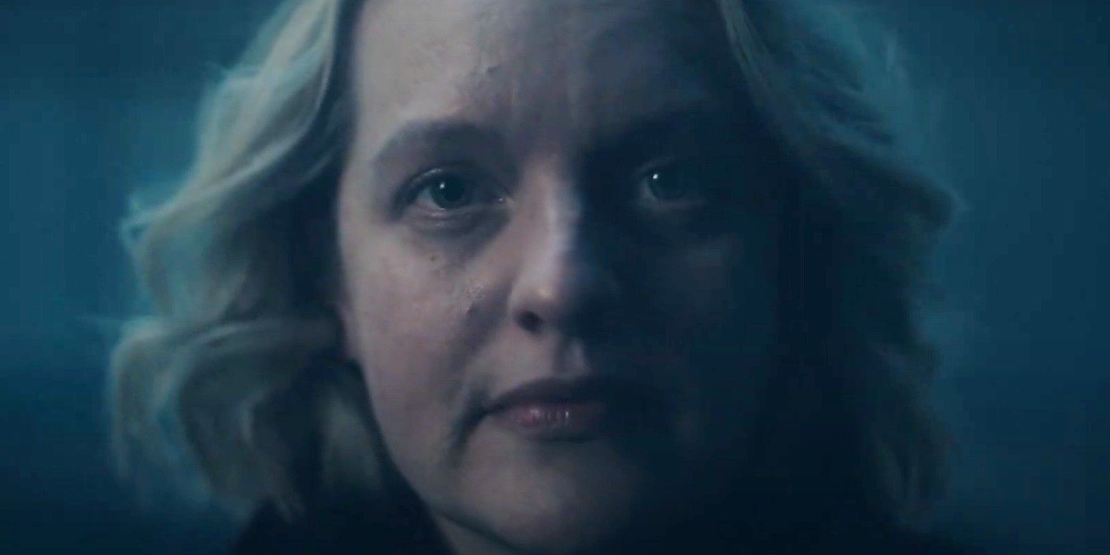 a close up of June staring ahead on a darkened background in The Handmaid's Tale season 6