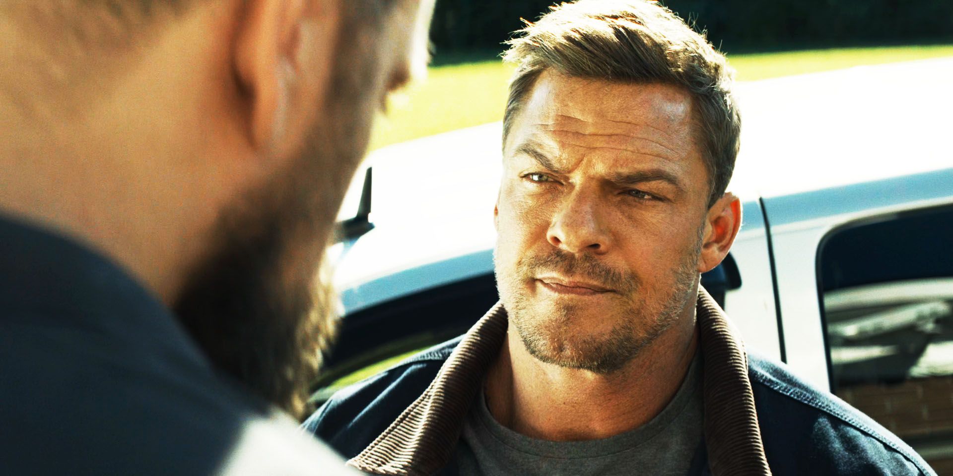 Alan Ritchson as Jack Reacher, looking at Paulie, in Reacher season 2, episode 1