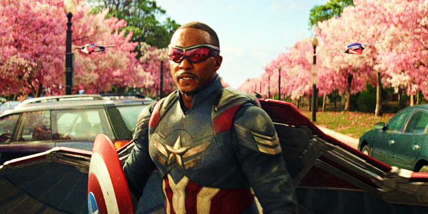 Anthony Mackie In Full Captain America Costume With Red Wing Drones Standing In Front Of Cherry Blossoms In Captain America Brave New World