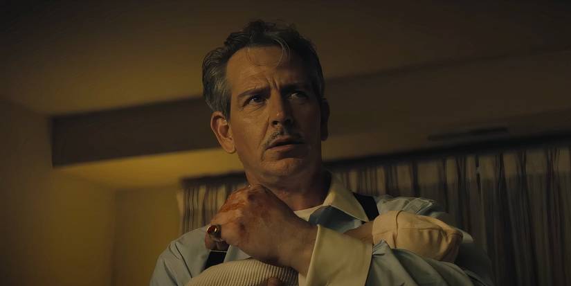 Ben Mendelsohn holding a baby in Freaky Tales