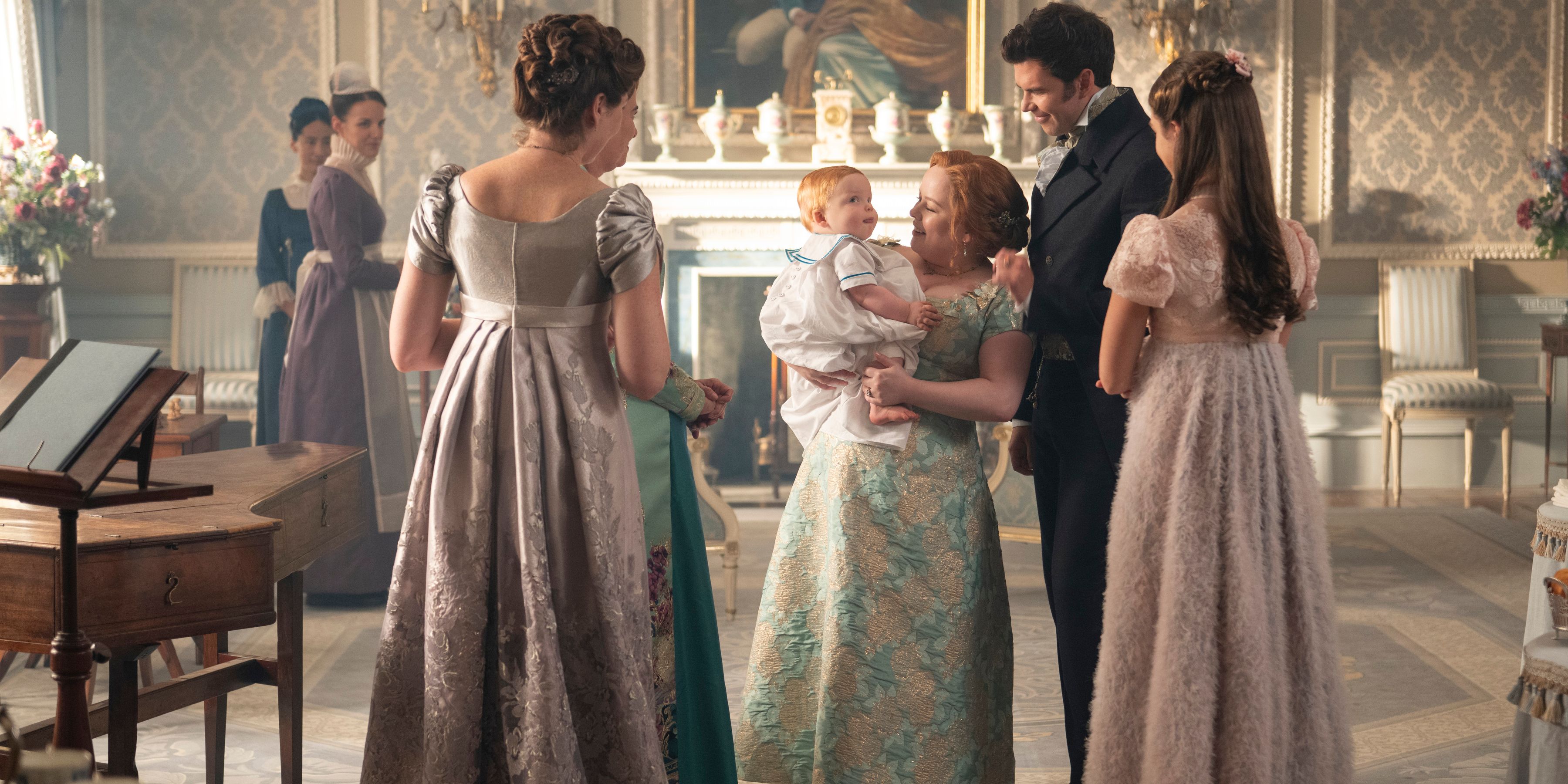 Violet Bridgerton (Ruth Gemmell), Portia Featherington (Polly Walker), Penelope Featherington (Nicola Coughlan), Colin Bridgerton (Luke Newton), &amp; Hyacinth Bridgerton (Florence Hunt) Admiring Colin &amp; Penelope&rsquo;s Baby In Bridgerton Season 4, Episode 1
