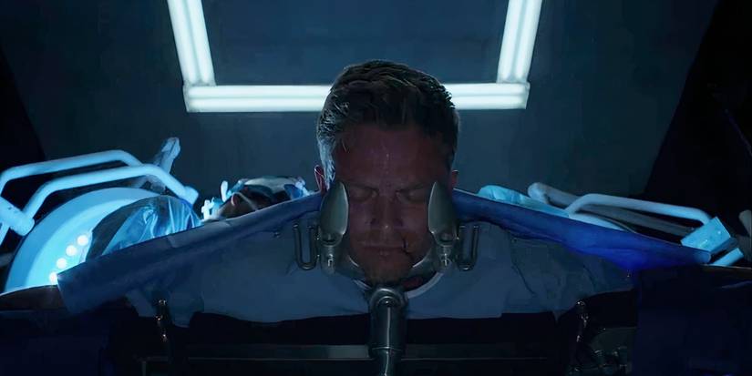 Wilson Bethel lying face down with his eyes closed in a surgical suite as doctors loom over him in Daredevil season 3 (2018)