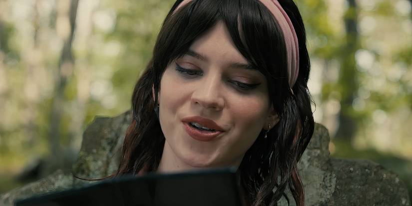 Sophie Thatcher as Iris looking down at a tablet in Companion